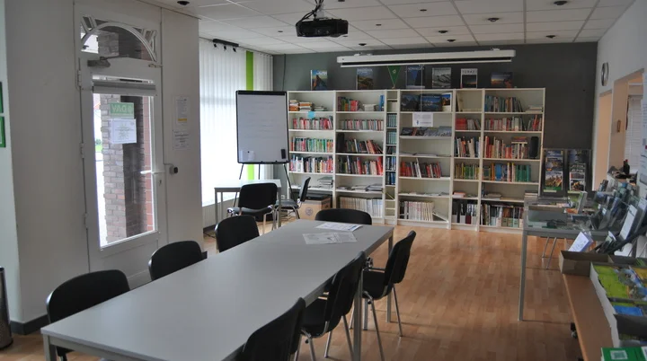 Geschaefstsstelle-Innenbereich | © geschaefstsstelle-innenbereich Geschaefstsstelle Innenbereich mit Tisch und Bücherregal  | © geschaefstsstelle-innenbereich