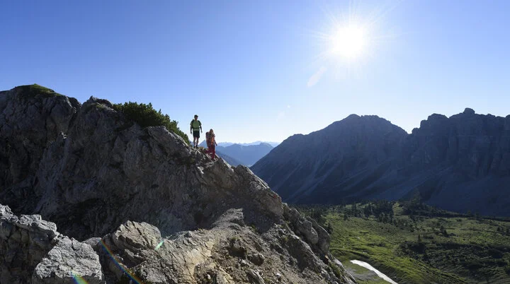 Wanderer im Sommer | © DAV / Wolfgang Ehn Zwei Wanderer auf einem Felsgrat. Im Hintergrund grüne Bergwiesen | © DAV / Wolfgang Ehn